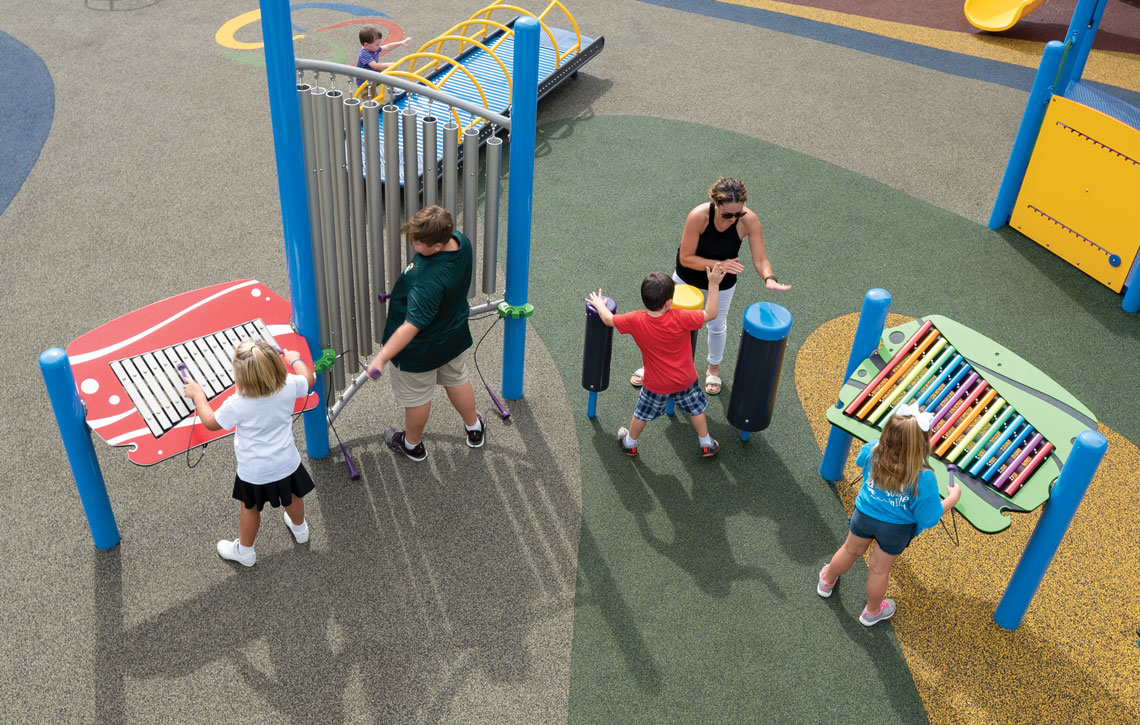 Family playing with musical playground equipment